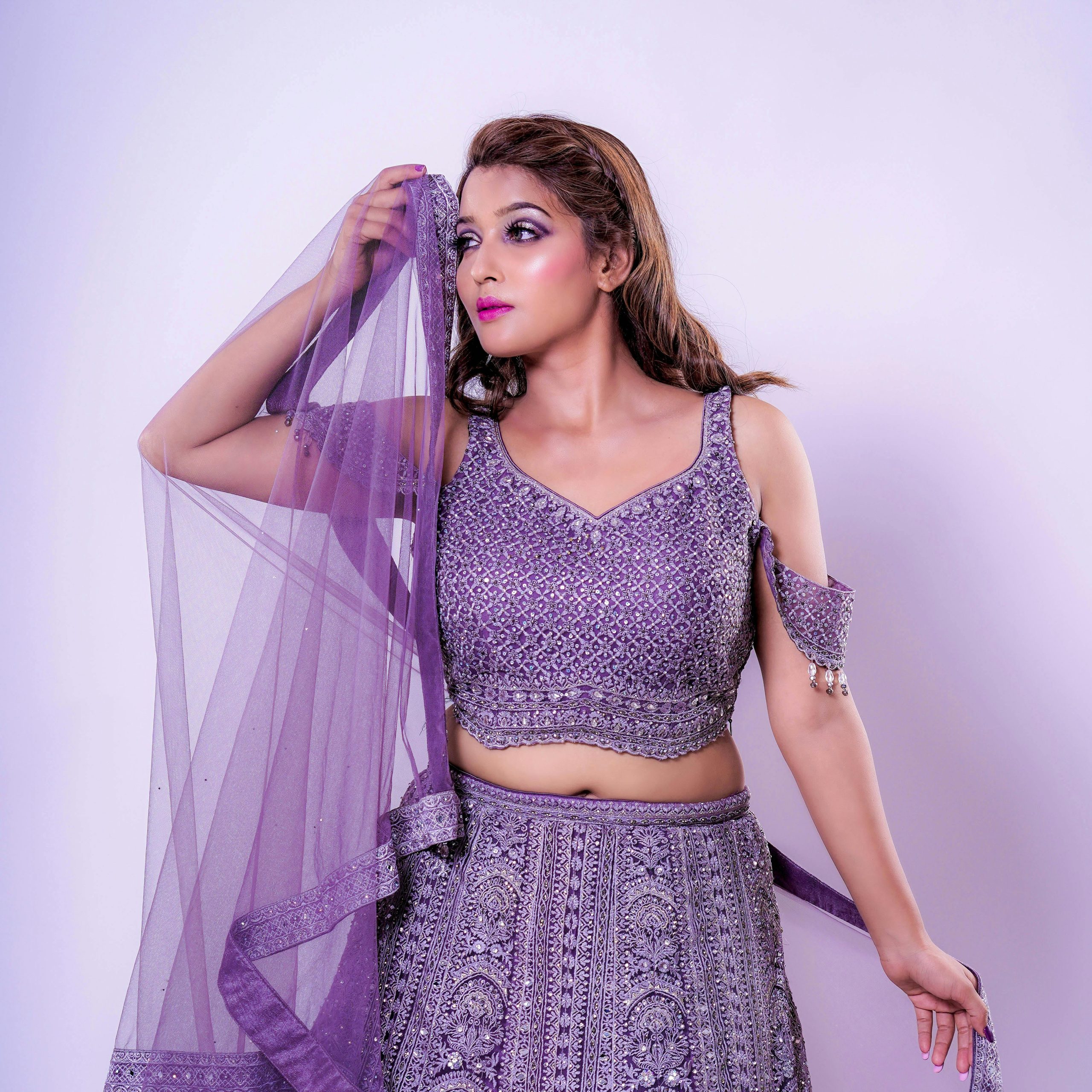Stunning woman in intricate purple traditional outfit, exuding elegance and grace.